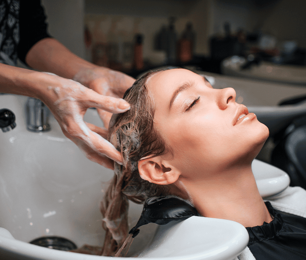 Woman getting her hair washed at a salon sink.